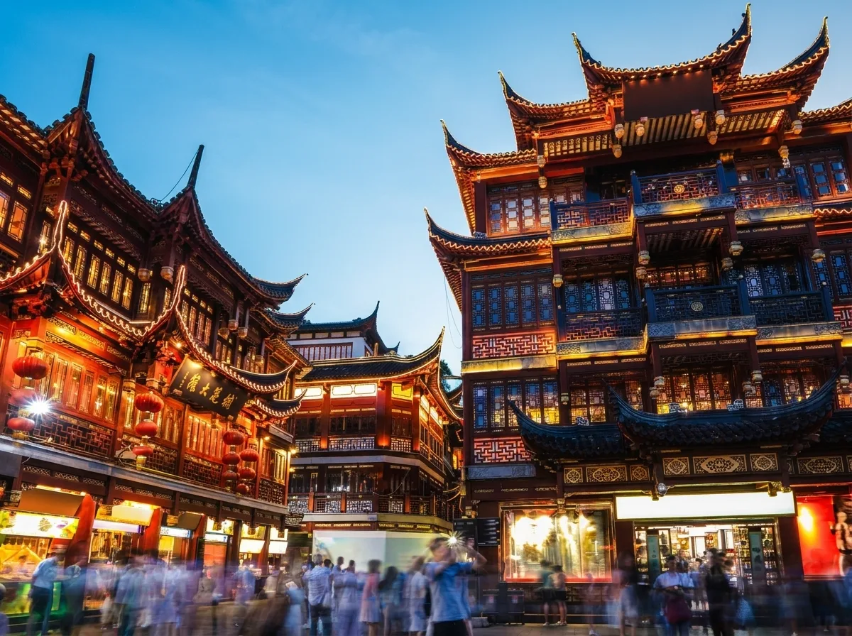 Illuminated traditional buildings and a busy pedestrian square in China
